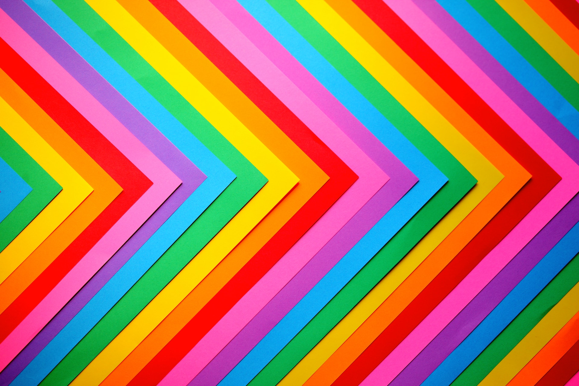 A close up of a rainbow flag made out of different pieces of paper.