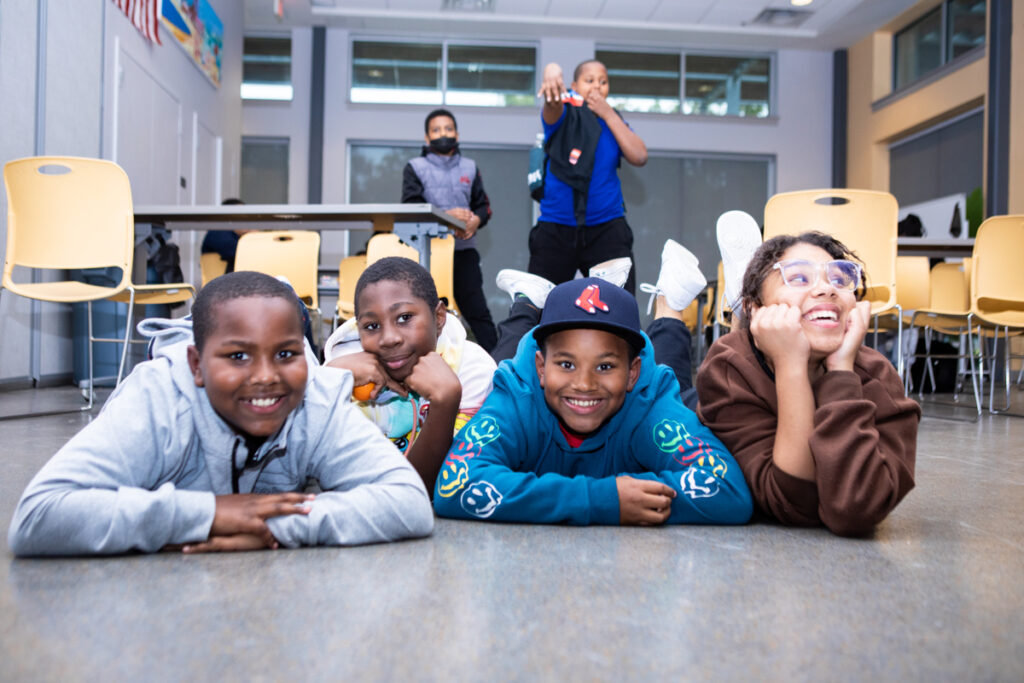 Smiling children lying on the floor looking at the camera