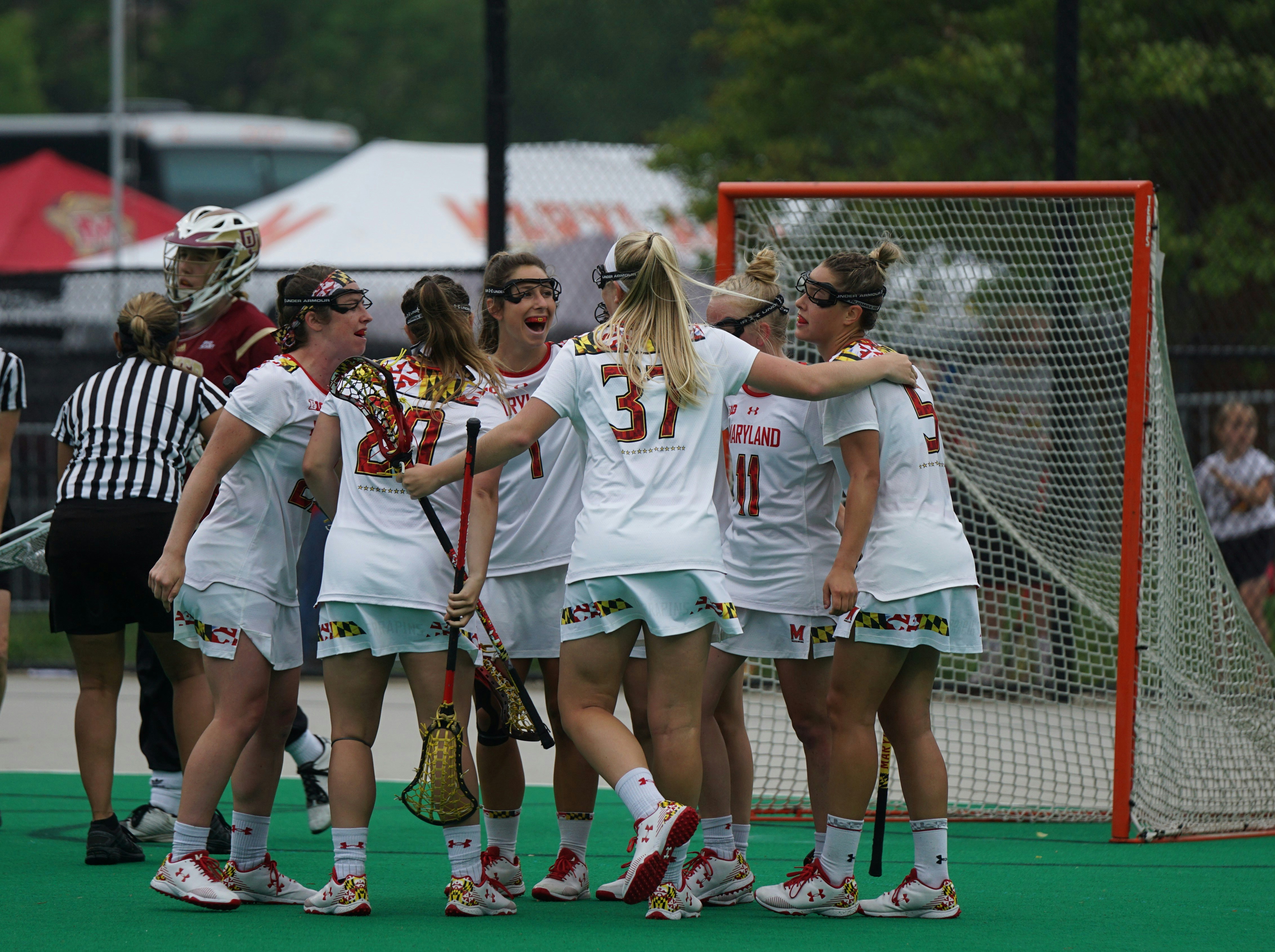 Group of girls celebrating after scoring in lacrosse game